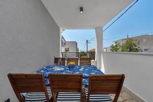 a dining room with a table and chairs on a balcony at Apartman Lovreta - Ivano in Makarska