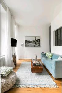 a living room with a blue couch and a coffee table at Kleinod am Park - Zentrum-Südost in Leipzig