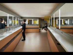 a man is standing in a public bathroom at 9h nine hours Nakasukawabata Station in Fukuoka