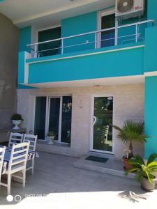 a blue building with chairs and a balcony at Деси Къща за гости 1 in Chernomorets