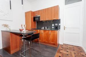 een keuken met houten kasten en een zwart aanrechtblad bij Charmant 2 pieces frontiere Monaco in Beausoleil +2 foto's