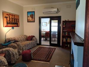 a living room with a couch and a tv at Walnut Cottage - 2 bedroom pet friendly country cottage in Bridgetown