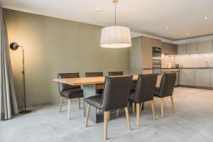 una sala da pranzo con tavolo in legno e sedie nere di Apartment JungfrauCenter Roteflue - GriwaRent AG a Interlaken