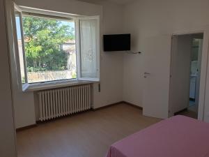 a bedroom with a window and a bed and a television at I TREPPONTI in Comacchio
