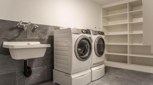 a washing machine and a sink in a laundry room at Apartment JungfrauCenter Roteflue - GriwaRent AG in Interlaken