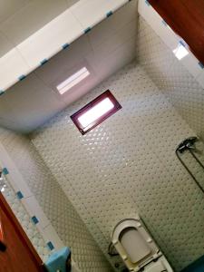 La salle de bains est pourvue de toilettes et d'une lumière au plafond. dans l'établissement Dar ezzitouna, à Oualidia