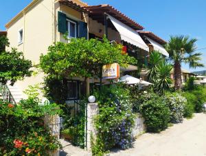 un bâtiment avec beaucoup de plantes et de fleurs dans l'établissement Grivas Apartments, à Sivota