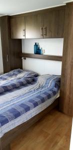 1 dormitorio con 2 camas y armarios de madera en De Zeeuwse Lûûkjes 1, en Serooskerke