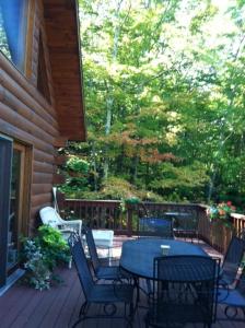 a patio with a table and chairs on a porch at The Catskill Cabin in Elka Park