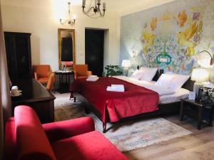 a bedroom with a large bed with a red blanket at Hotel Ester in Kraków