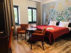 a bedroom with a red bed and a table and chairs at Hotel Ester in Kraków