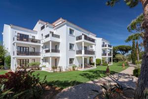 an exterior view of a white apartment building at Pine Cliffs Village & Golf Suites in Albufeira