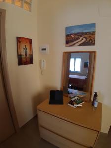 a room with a desk with a mirror and a window at A DUE PASSI DAL BLU in Marina di Gioiosa Ionica