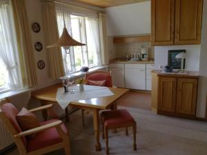 eine Küche mit einem Tisch und Stühlen im Zimmer in der Unterkunft Reetdachhus an de Diek in Sankt Peter-Ording