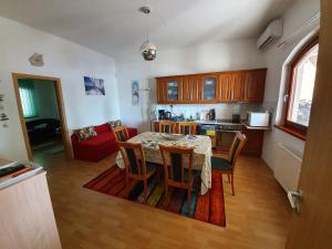 een keuken en eetkamer met een tafel en stoelen bij Lido Dalma Apartman 1 in Fonyód