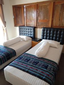 dwa łóżka siedzące obok siebie w pokoju w obiekcie JOGLOPARI GuestHouse bukan untuk pasangan non pasutri w mieście Bantul