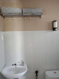 Baño blanco con lavabo y aseo en JOGLOPARI GuestHouse bukan untuk pasangan non pasutri, en Bantul