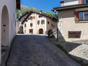 una strada di ciottoli nel mezzo di due edifici di Palazzo Mysanus Samedan a Samedan