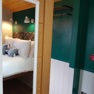una camera da letto con un letto e uno specchio di Annascaul Train Carriage suit couple and 2 children ad Anascaul Altre 14 foto