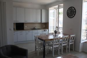 L'ALBATROS في غرانفيل: مطبخ وغرفة طعام مع طاولة وكراسي