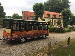 a bus is parked in front of a house at Hotel Vierhouten in Vierhouten