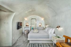 um quarto com uma cama num quarto branco em Diamond Luxury Suites em Oia