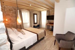 a bedroom with a bed and a chair in a room at Villa Teuta in Trogir