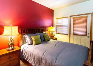ein Schlafzimmer mit einem Bett und einer roten Wand in der Unterkunft Elegant Cottage with Wonderful Views near FH Lake in Show Low