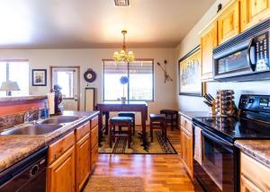 eine Küche mit Holzschränken und ein Esszimmer in der Unterkunft Elegant Cottage with Wonderful Views near FH Lake in Show Low