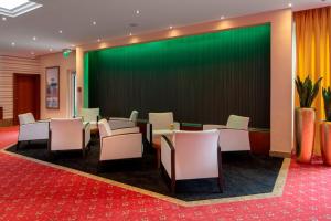 a conference room with chairs and a green screen at Hotel Schweizer Hof Thermal und Vital Resort in Bad Füssing