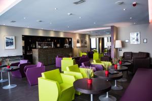 a restaurant with purple and green chairs and tables at Mercure Villefranche en Beaujolais in Villefranche-sur-Saône