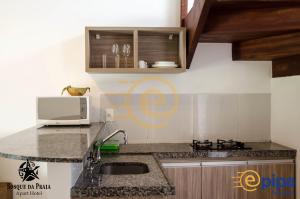 a kitchen with a sink and a microwave at Bosque da Praia - ePipa in Pipa