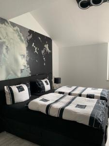 a bedroom with two beds and a poster of a man at Luxus Appartement Brühlervorstadt Erfurt in Erfurt