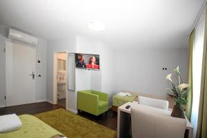 a living room with a tv on the wall at Hotel-Restaurant Axion in Weil am Rhein