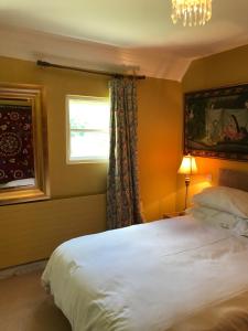 a bedroom with a bed and a window and a chandelier at Corriebeg Cottage in Borris