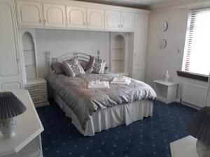 een slaapkamer met een bed met twee dienbladen erop bij Hilltop House in Airdrie