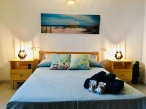 a bedroom with a bed with blue sheets and two lamps at CASA PAQUITA ¡¡¡VISTAS ESPECTACULARES!!! in Sant Josep de sa Talaia