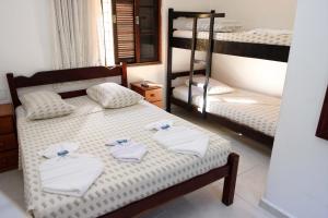 a bedroom with two bunk beds with towels on a bed at Hotel Águas Vivas in Caraguatatuba