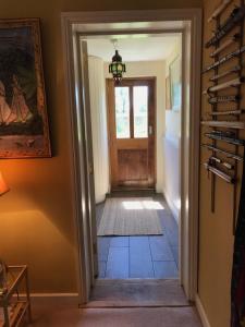 un pasillo con una puerta que conduce a una habitación en Corriebeg Cottage, en Borris