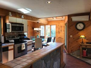 a kitchen with wooden walls and a clock on the wall at Mink Hollow Lodge in Elka Park
