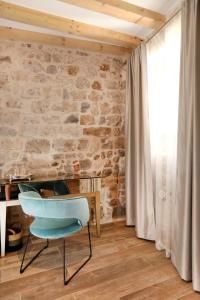 a blue chair in a room with a stone wall at Villa Teuta in Trogir