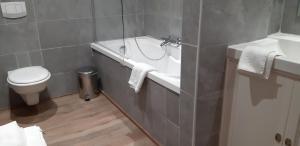 een badkamer met een bad, een toilet en een wastafel bij B&B Ter Brugge in Jabbeke