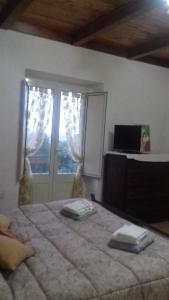een slaapkamer met een groot bed en een raam bij L' Albarosa affittacamere e b&b in Spigno Saturnia