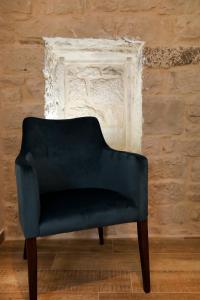 een blauwe stoel voor een stenen muur bij Villa Teuta in Trogir