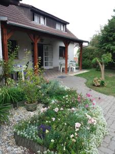 a garden in front of a house with flowers at Vincze Vendégház in Körmend