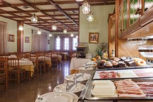 un restaurante con mesas, sillas y comida a la vista en Hotel Restaurante Emilio, en Hellín