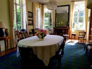 a dining room with a table with a vase of flowers on it at Le Bocage Fleuri in Mons