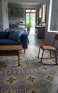 Leuilly-sous-Coucy的住宿－La buissonnière，一间带蓝色沙发的客厅和一间厨房