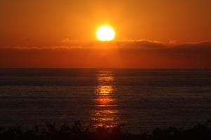 a sunset over the ocean with the sun in the sky at Hotel Águas Vivas in Caraguatatuba