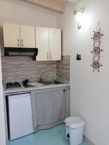 a kitchen with a sink and a stove at Residence Il Melograno in Lampedusa